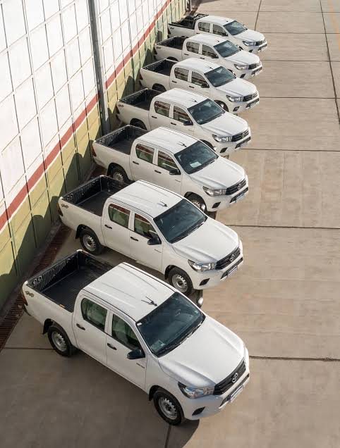 Camionetas Toyota Hilux doble cabina alineadas en playón antes de la entrega